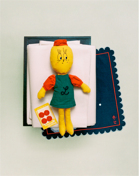 Toy figure of a character with a red hat and green dress on a white background