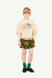 Image of a boy dressed in The Animals Observatory. The outfit consists of a cap, a sweatshirt, printed shorts, and green socks. The image shows the outfit from the front.